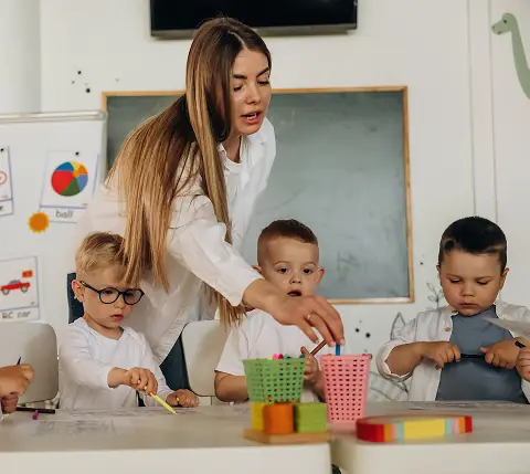 Teacher helping children with an early learning activity