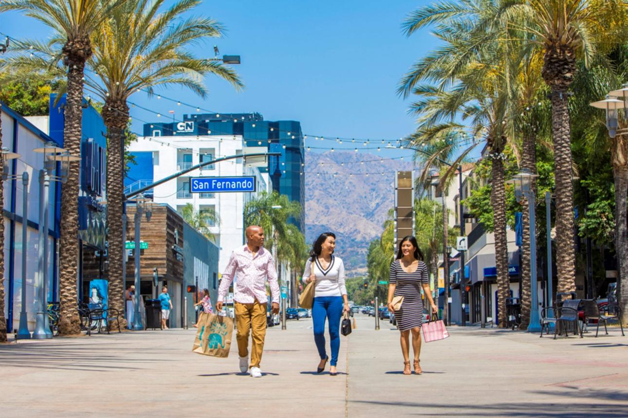 Sunny downtown Burbank pedestrian street with palm trees and shoppers