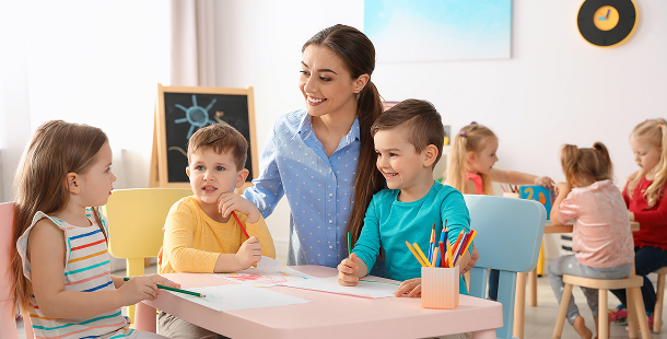 Talk-EarlyEd — teacher helping children draw in a classroom